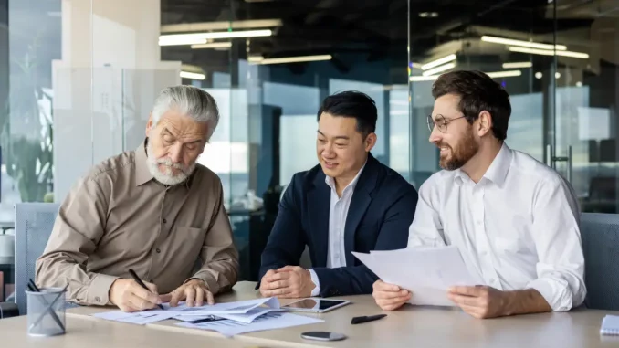Drei Geschäftsleute sitzen im Büro und optimieren strategisch mit dem Prinzip des Morphologischen Kasten den Arbeitsalltag.