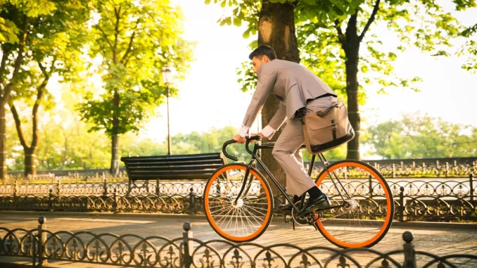Ein Mann im Business-Outfit fährt mit dem Rad zur Arbeit.
