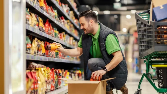 Ein Mann räumt im Supermarkt ungestört Regale ein.