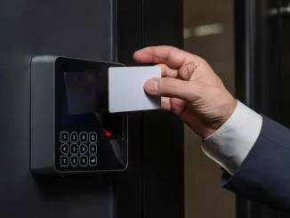 Ein Mann im Business-Outfit öffnet die Tür mit einer Schlüsselkarte zum Büro. Zeitgleich wird mit der Key-Card seine Arbeitszeit erfasst.