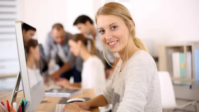 Auszubildende Steuerfachangestellte sitzt in der Kanzlei am Schreibtisch.