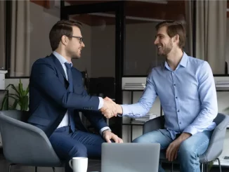 Chef dankt seinem Angestellten mit einem Handschlag im Büro und schenkt ihm damit Wertschätzung.