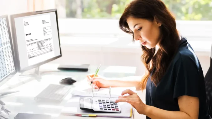 Buchhalterin verwendet Software am Computer, um EU-Ausland Rechnung zu schreiben.