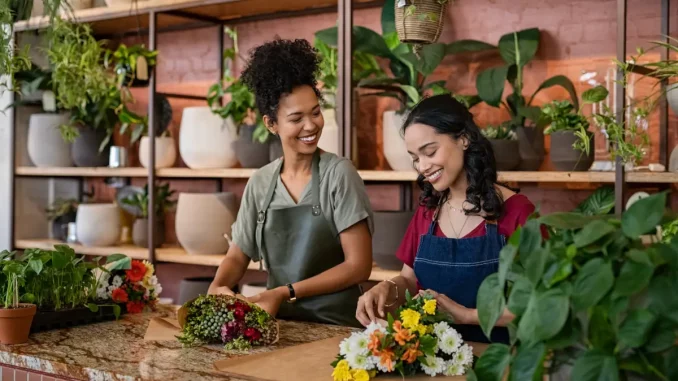 Zwei Frauen binden Blumen in einem Blumengeschäft