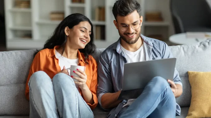 Ein junges Paar sucht gemeinsam im Internet nach Jobs