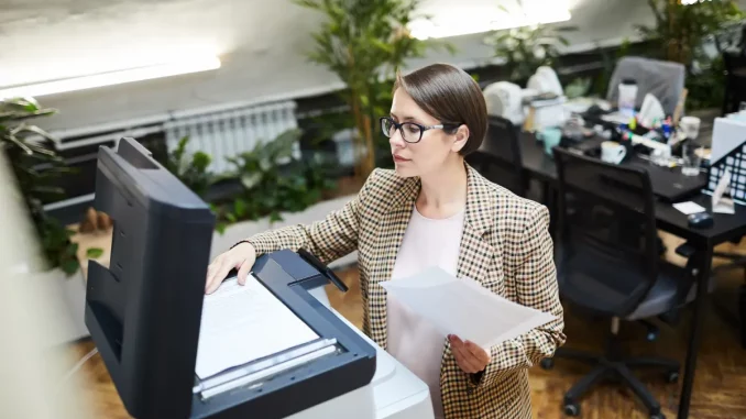 Frau betätigt Drucker im Büro