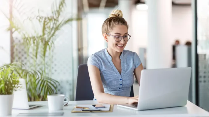 Junge Frau arbeitet am Laptop in einem Büro